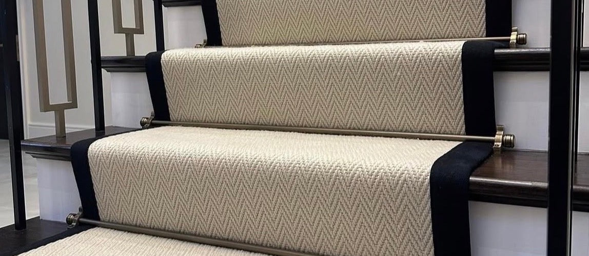Herringbone wool stair runner with black binding and brass stair rods