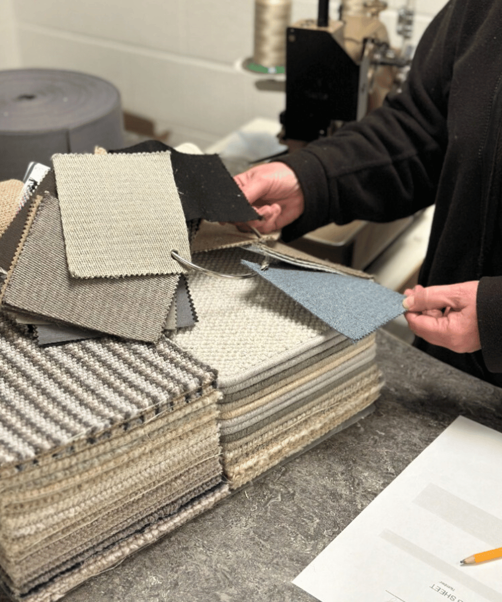 A stack of wool carpet samples being sorted by hand